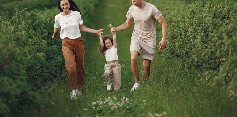 Joyful family enjoying a fun day outdoors in a green field, epitomizing togetherness and happiness.